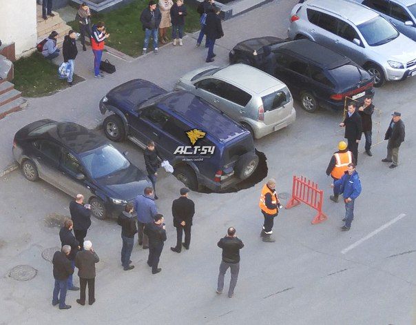 На Октябрьской внедорожник провалился в огромную дыру в асфальте